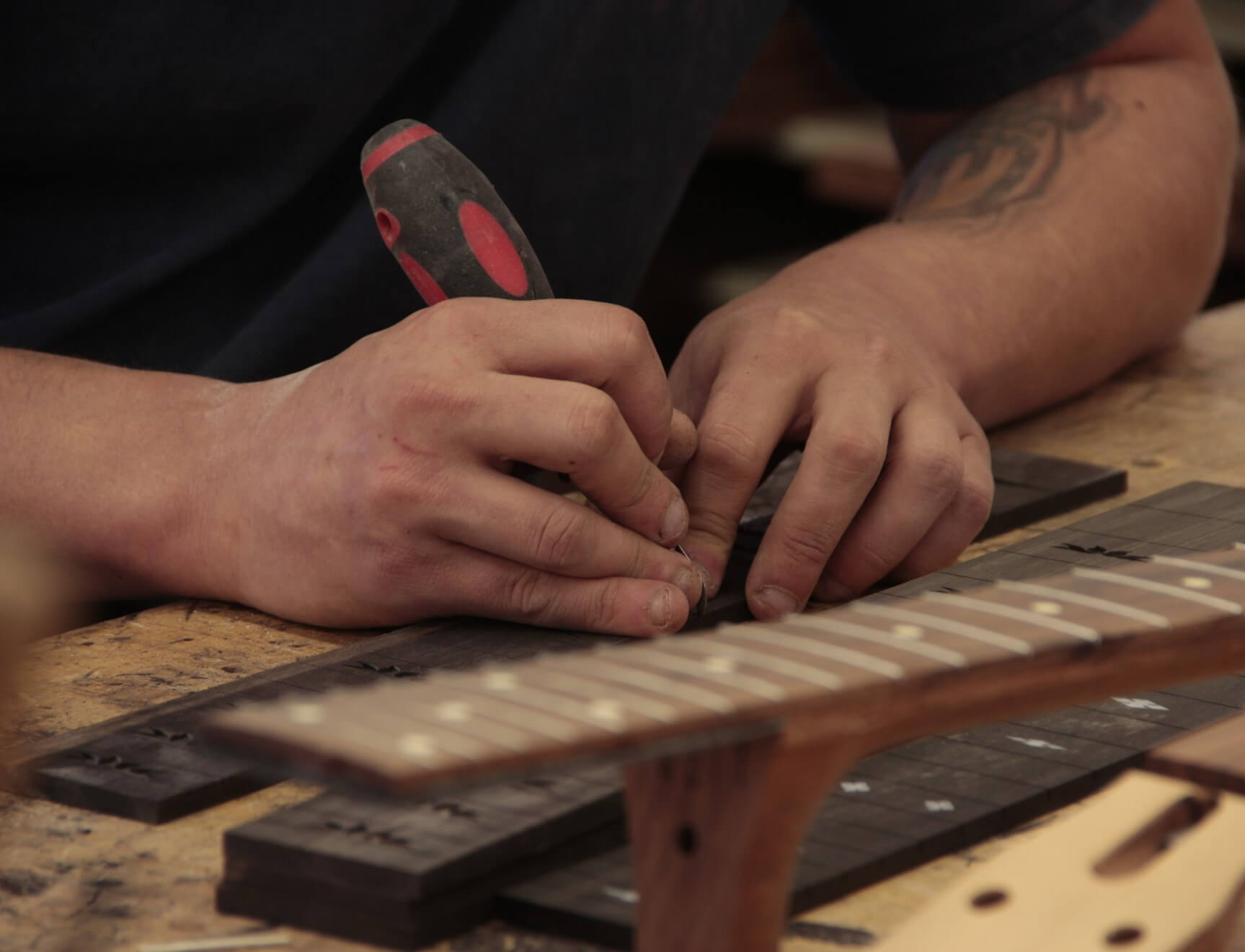 Person working on Beard guitar fretboard