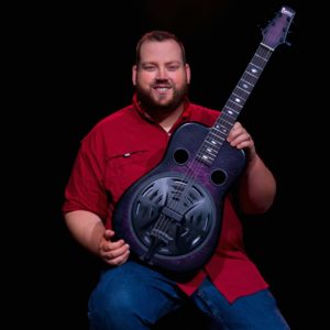 Josh Swift holding Beard resonator guitar